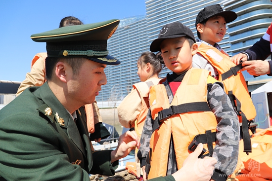 边防民警帮助小朋友穿好救生衣