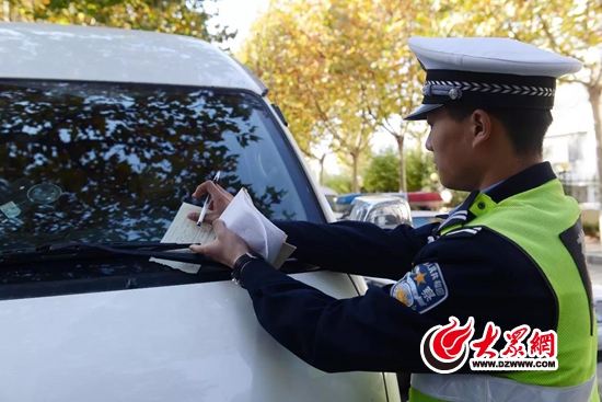 交警直属大队民警在给违法停车的车辆开罚单