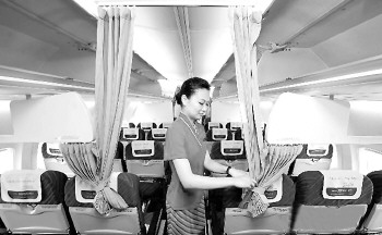 2010年, 南航在机舱内用门帘分隔出“高端经济舱” 与“普通经济舱” 。 (资料片)